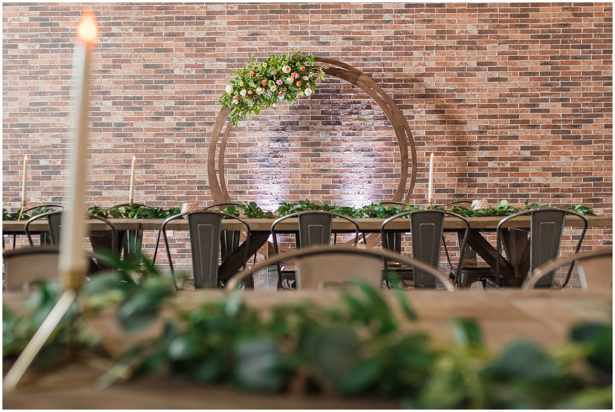 Wooden round floral arch, Industrial Edison bulb chandelier and farmhouse tables | The Foundry | Utah Wedding Venue | Shout-out Saturday | Jessie and Dallin Photography