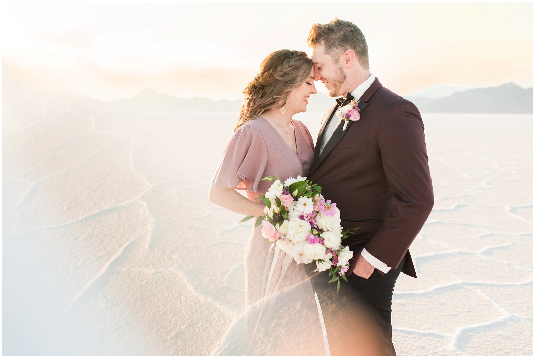 Couple in dusty rose dress and burgundy suit with white and pink bouquet at the Bonneville Salt Flats Milky Way Anniversary Session | Jessie and Dallin Photography