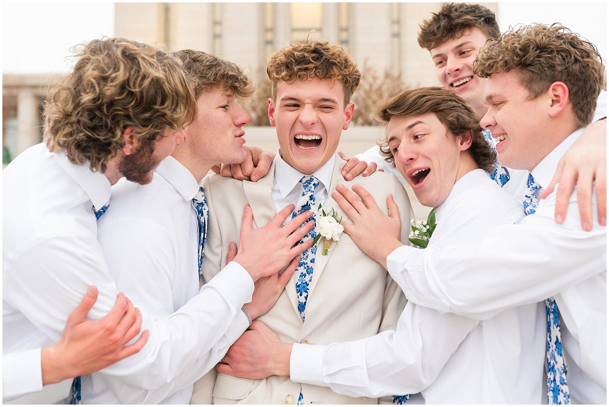 Groom surrounded by groomsmen candid moment | Oquirrh Mountain Temple and Draper Day Barn Winter Wedding | Jessie and Dallin Photography