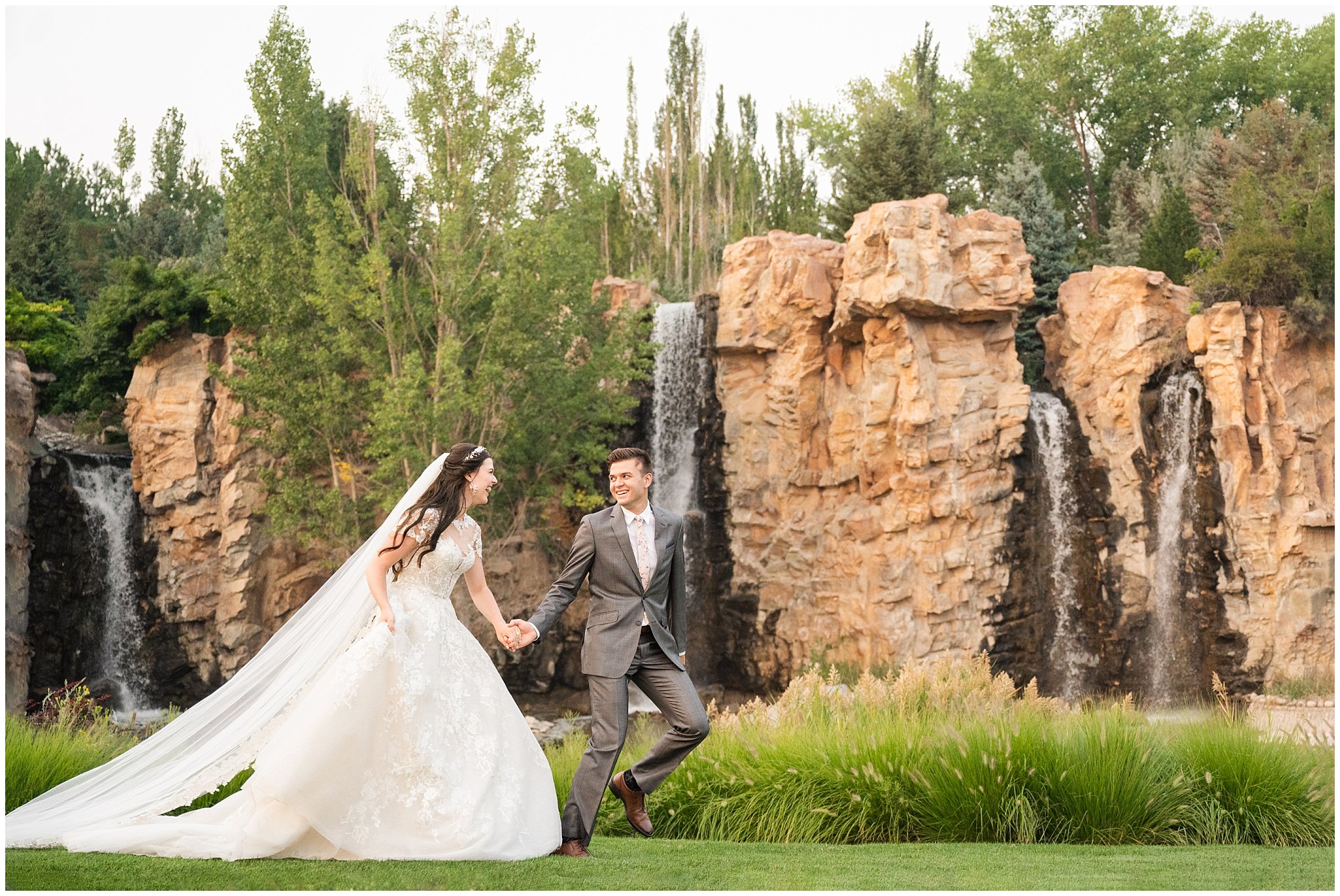 Bride and Groom in front of waterfalls during wedding portraits during the summer surrounded by flowers and gardens | Thanksgiving Point Ashton Garden Formal Session | Jessie and Dallin Photography