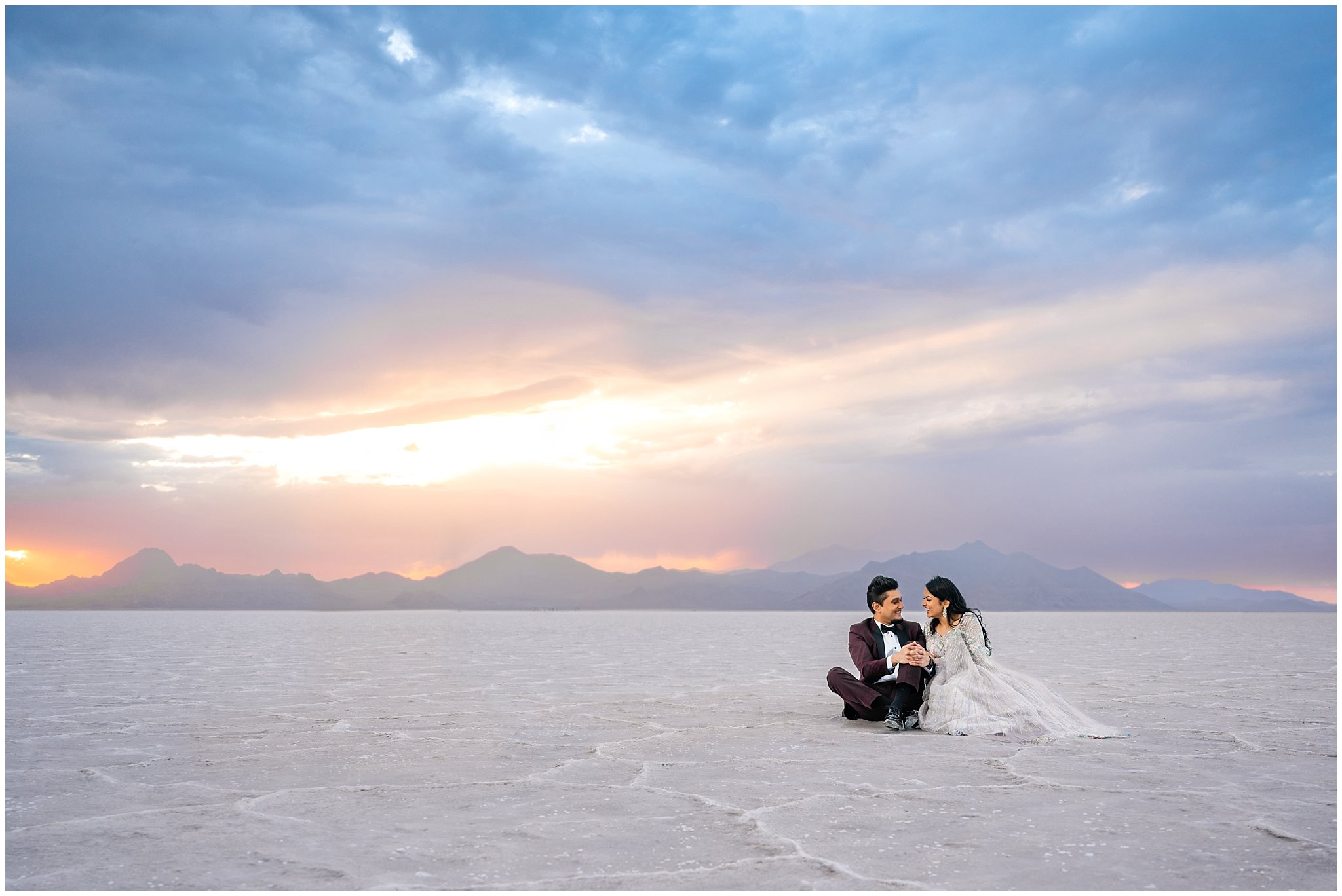 Couple sitting together during their Indian wedding session at the Bonneville Salt Flats