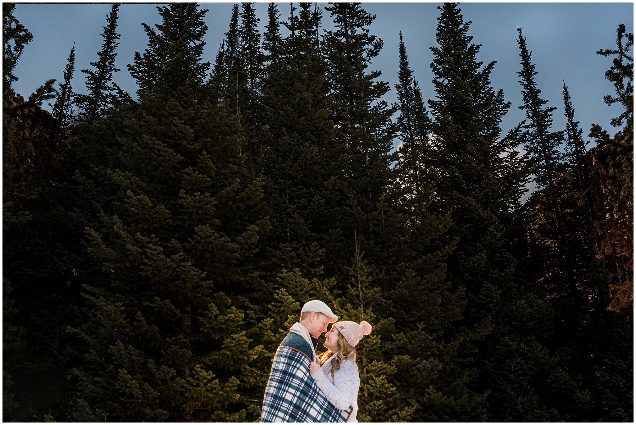 Couple holding each other close in front of a wall of pine trees in the snow | Big Cottonwood Canyon Winter Engagement Session | Jessie and Dallin Photography