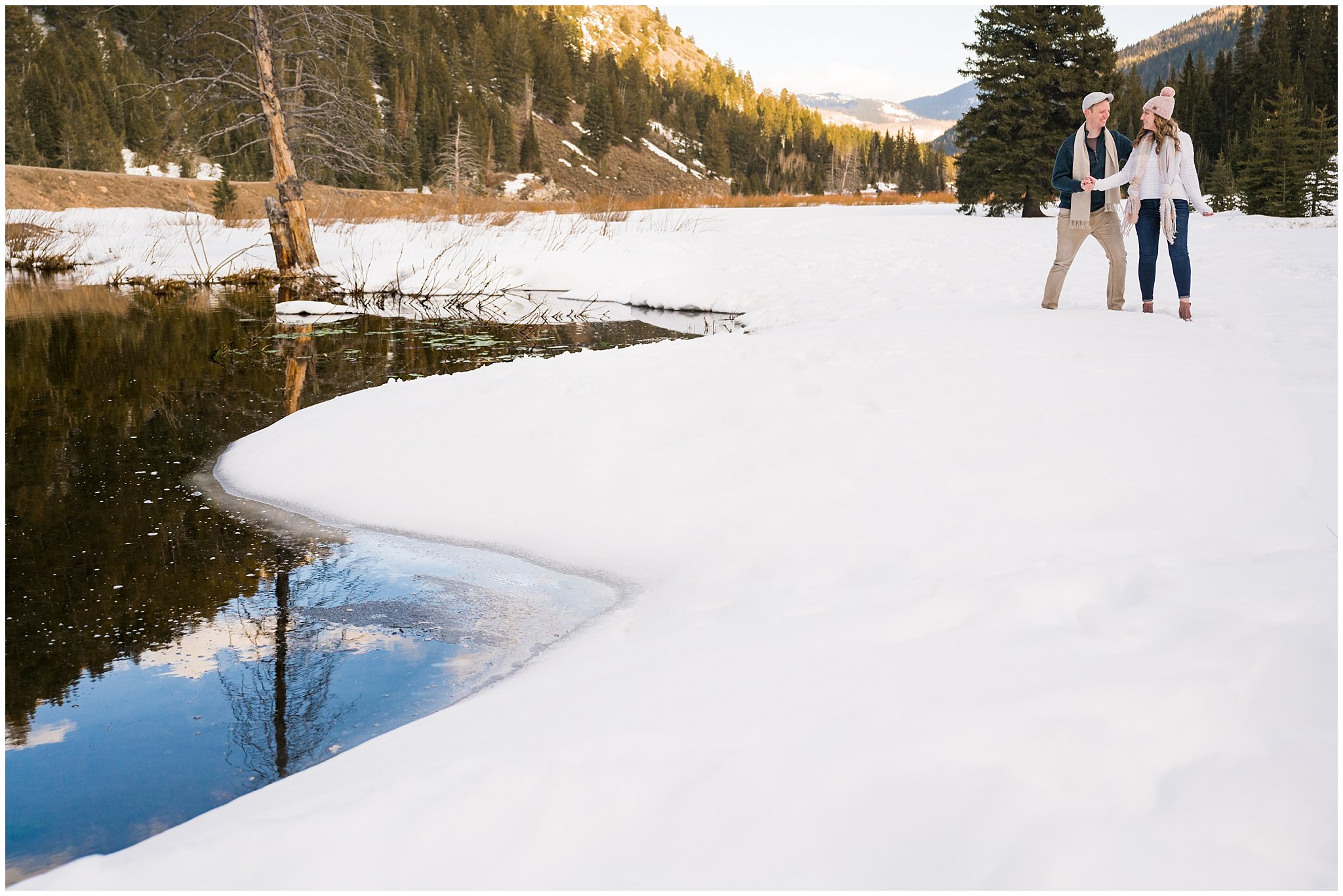 Couple in cute winter outfits sharing candid moments in the Utah mountains in the snow | Big Cottonwood Canyon Winter Engagement Session | Jessie and Dallin Photography