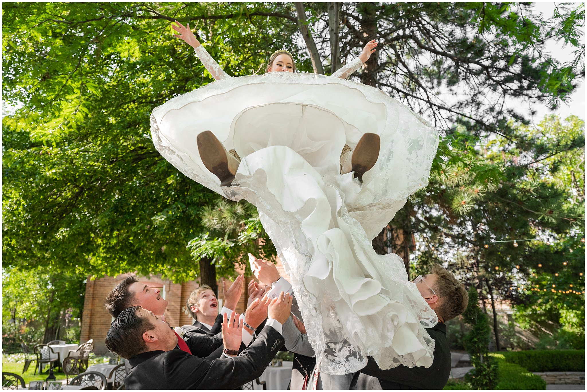 Black and red wedding party portraits as the bride is tossed in their air outside at Eldredge Manor | Bountiful Temple and Eldredge Manor Wedding | Jessie and Dallin Photography