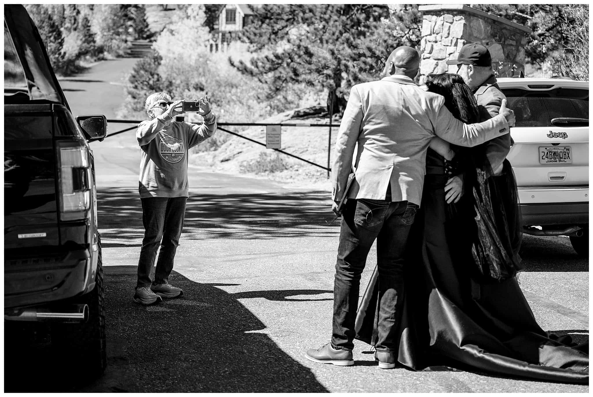 Bride and groom get photo taken by tourists before their ceremony in Estes Park | Fall Rocky Mountain National Park Elopement | Jessie and Dallin Photography