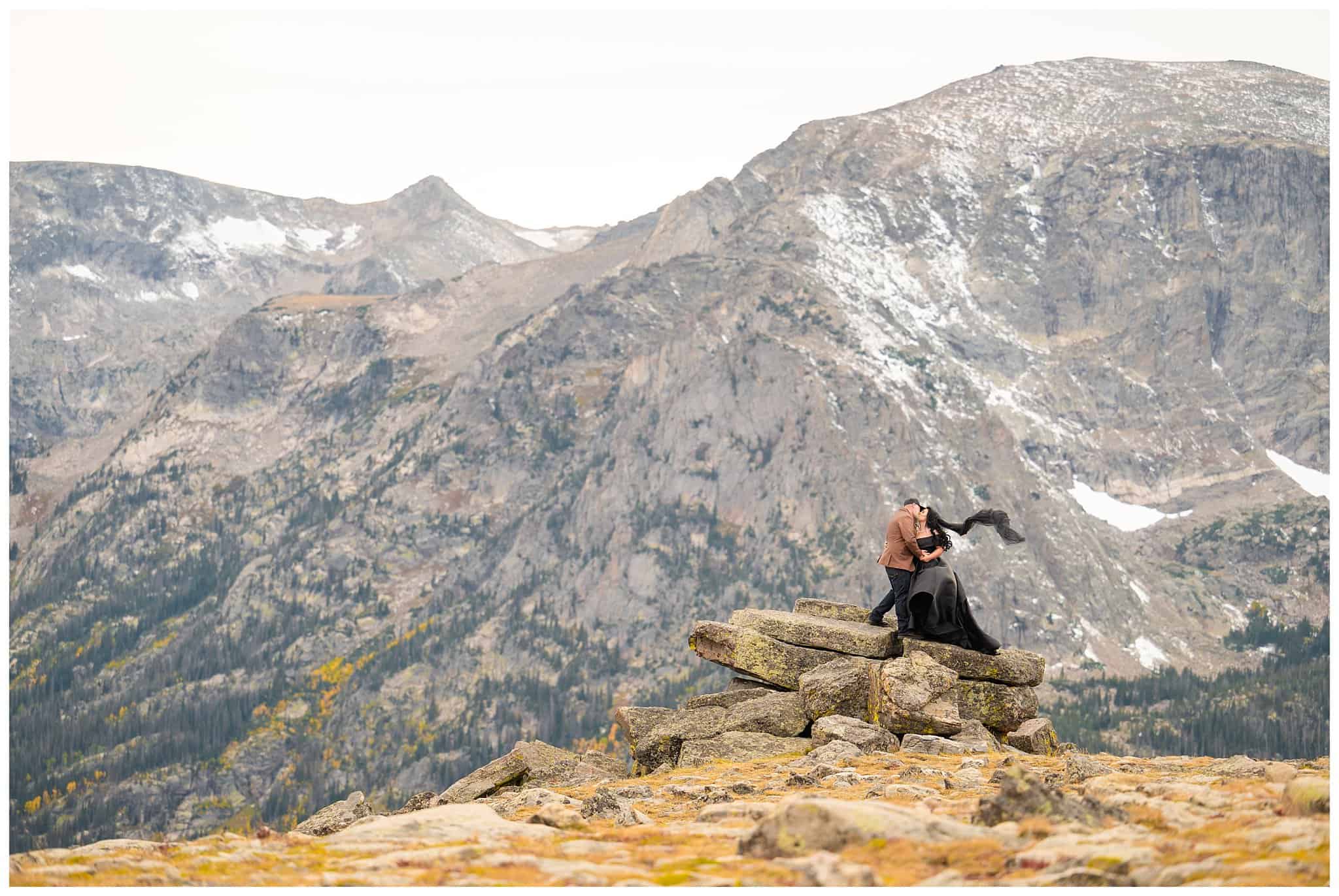 Bride in black dress and groom in brown leather jacket sharing moments in the windy tundra at Rocky National Park | Fall Rocky Mountain National Park Elopement | Jessie and Dallin Photography