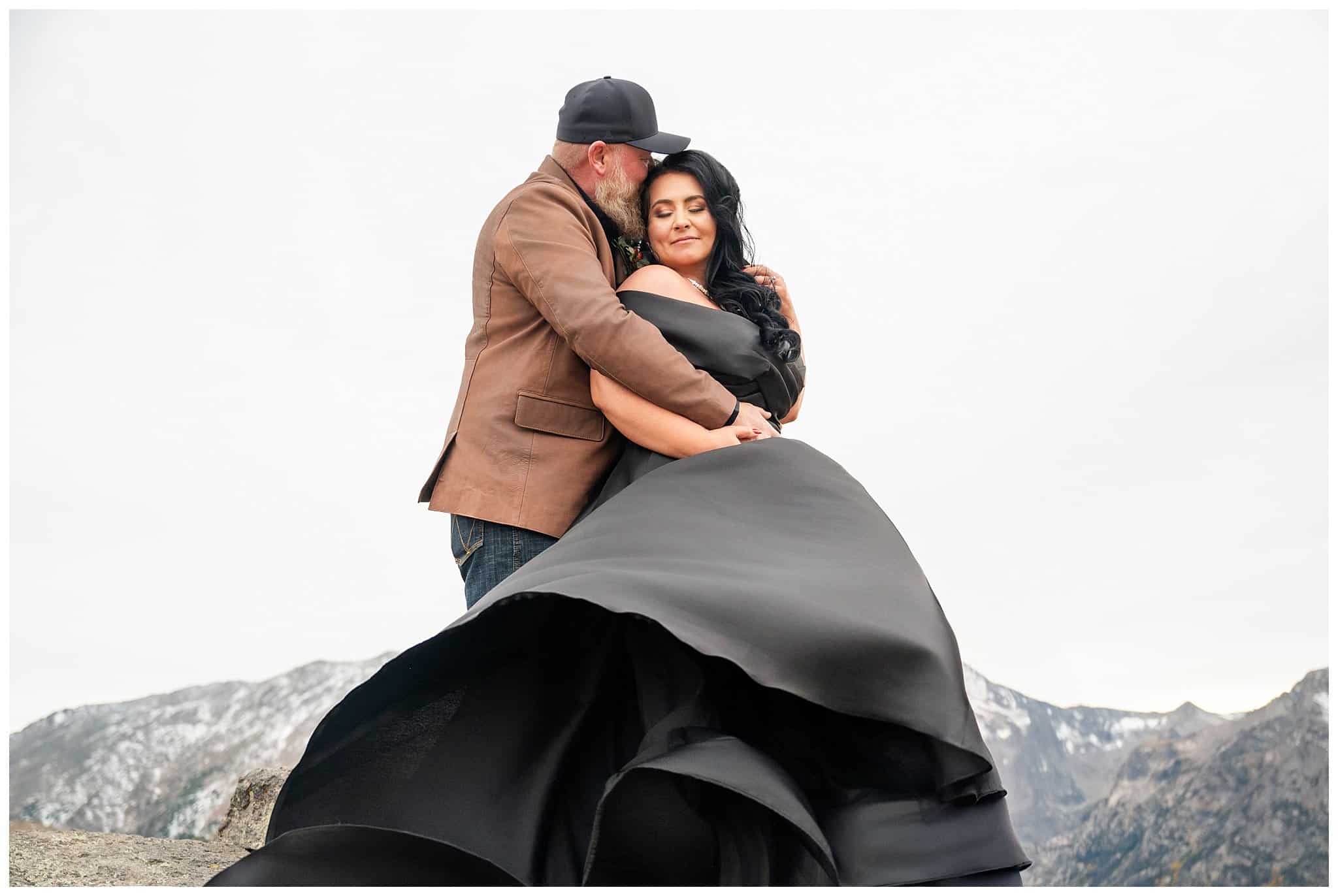 Bride in black dress and groom in brown leather jacket sharing moments in the windy tundra at Rocky National Park | Fall Rocky Mountain National Park Elopement | Jessie and Dallin Photography