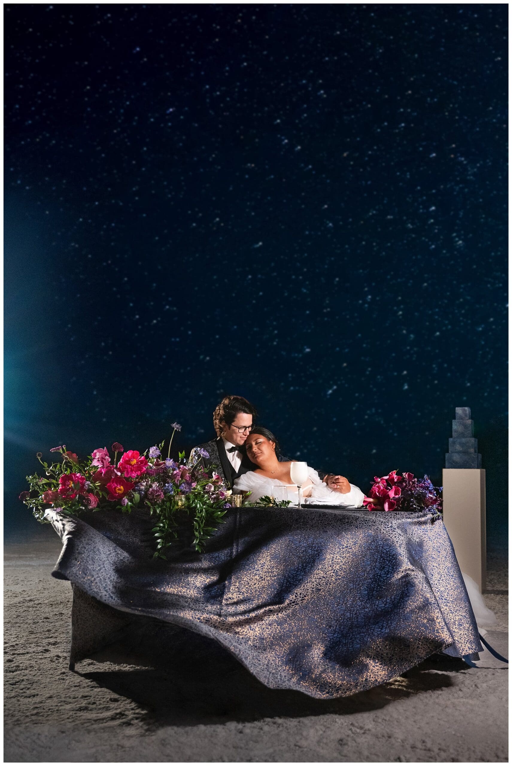 Bride and Groom share a moment together beneath the stars at their sweethearts table at the Bonneville Salt Flats during inspiration elopement | Jessie and Dallin Photography
