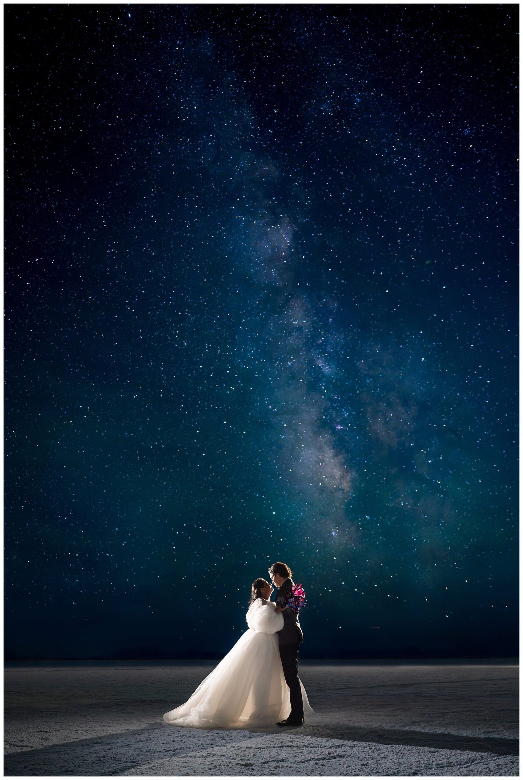 Bride and Groom share a moment together beneath the Milky Way at the Bonneville Salt Flats during inspiration elopement | Jessie and Dallin Photography