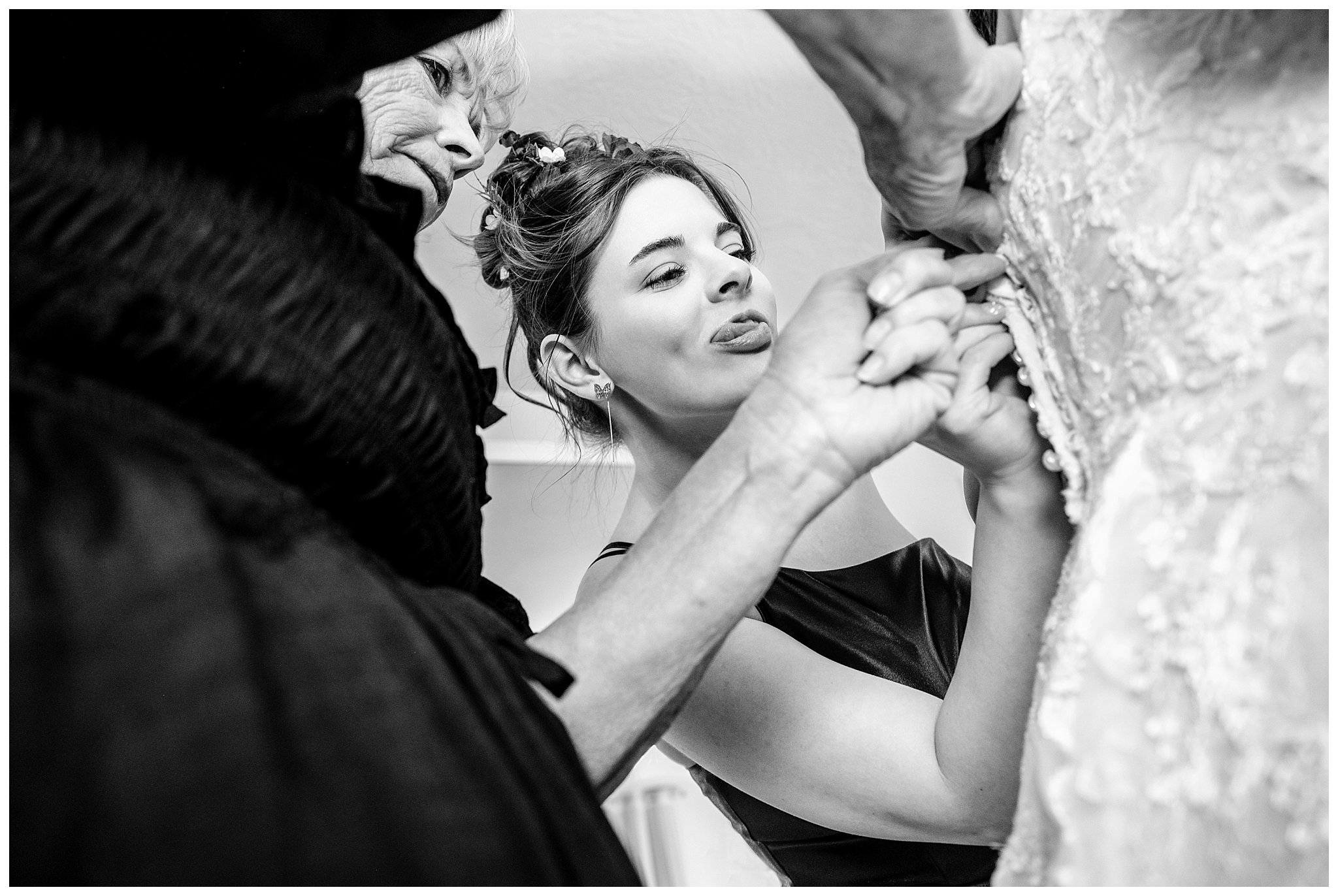 Family helps bride get into dress and daughter sticks her tongue out while buttoning dress | Star Wars Themed Wedding at Oak Hills Utah | Jessie and Dallin Photography