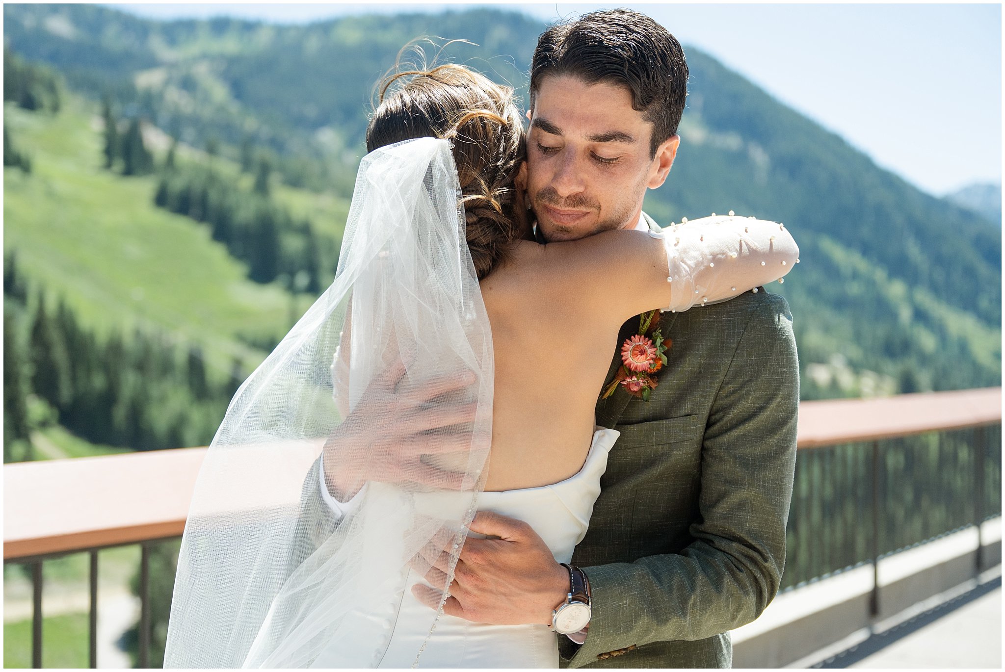 Bride and groom sharing a first look on the rooftop of The Cliff Lodge. Groom wearing a sage green suit and golden tie, bride in a strapless dress with gloves and veil | Snowbird Summit Summer Wedding | Jessie and Dallin Photography