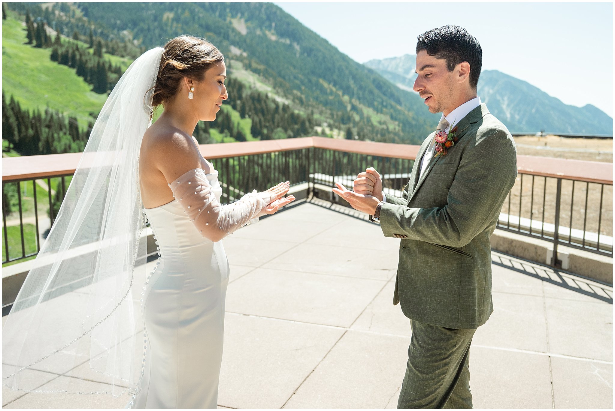 Bride and groom sharing a first look on the rooftop of The Cliff Lodge. Groom wearing a sage green suit and golden tie, bride in a strapless dress with gloves and veil | Snowbird Summit Summer Wedding | Jessie and Dallin Photography