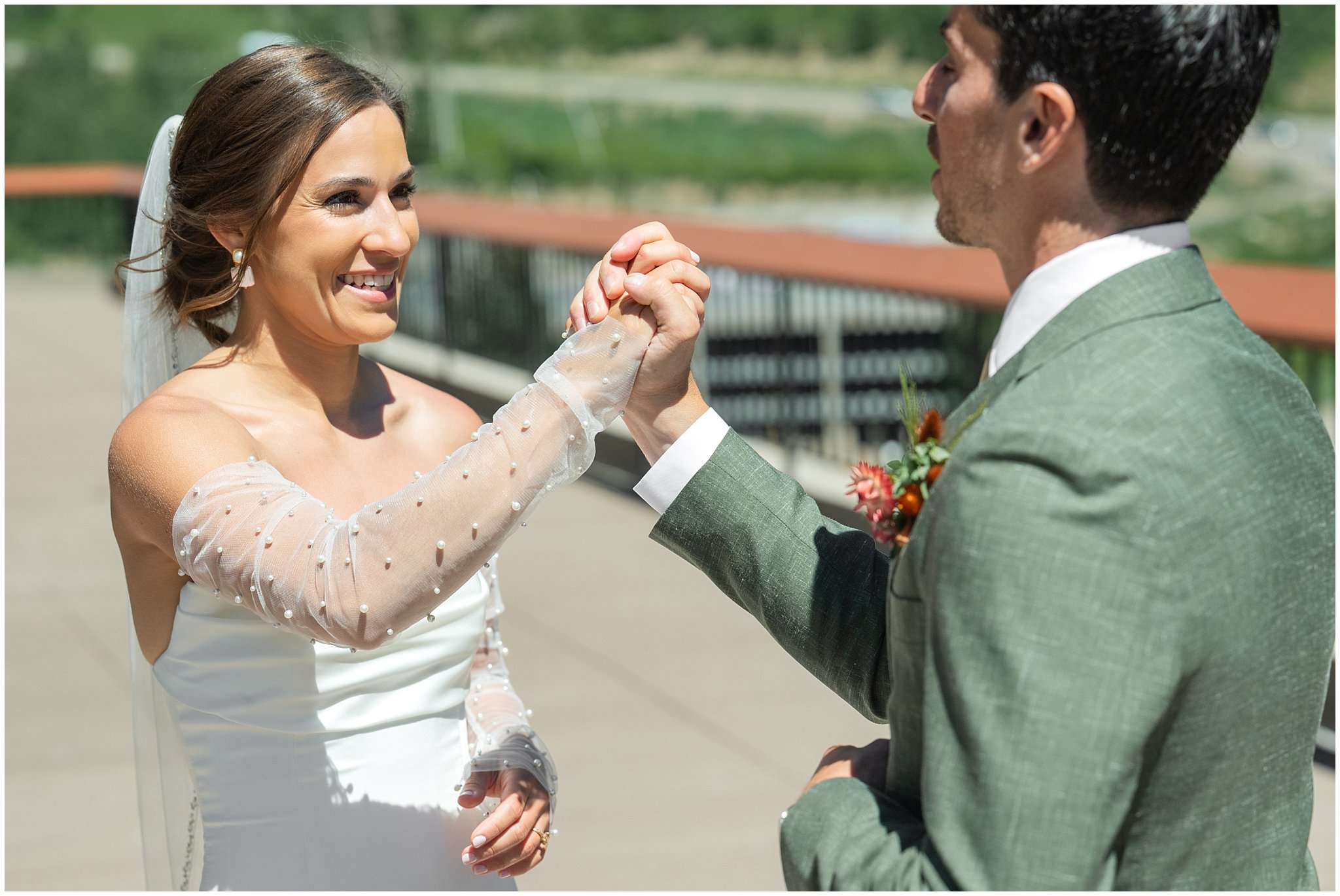 Bride and groom sharing a first look on the rooftop of The Cliff Lodge. Groom wearing a sage green suit and golden tie, bride in a strapless dress with gloves and veil | Snowbird Summit Summer Wedding | Jessie and Dallin Photography