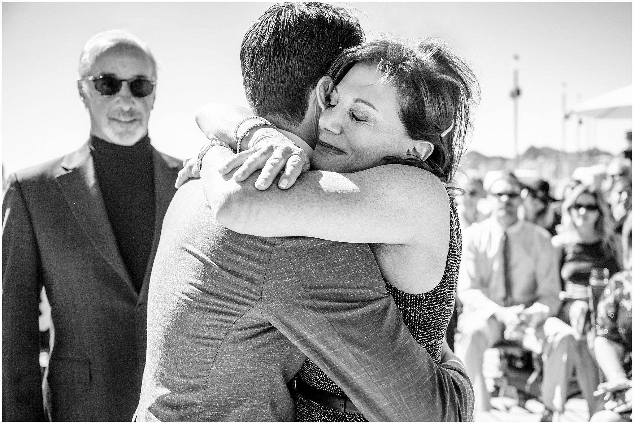 Mother of the groom gives him a huge hug at the bottom of the aisle before the ceremony | Snowbird Summit Summer Wedding | Jessie and Dallin Photography