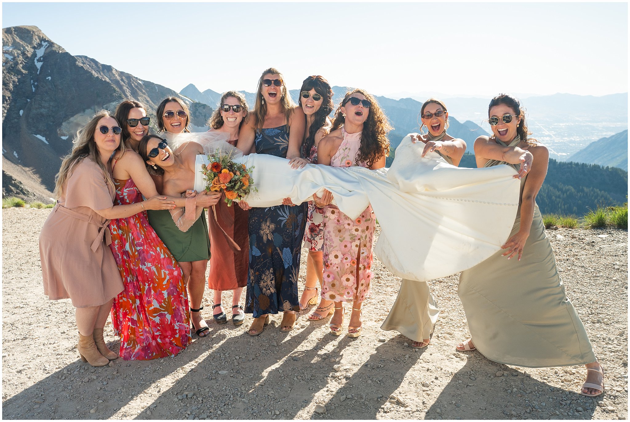 Bride and groom do funny poses with friends on top of the mountain. Groom wearing a sage green suit and golden tie, bride in a strapless dress with gloves and veil | Snowbird Summit Summer Wedding | Jessie and Dallin Photography