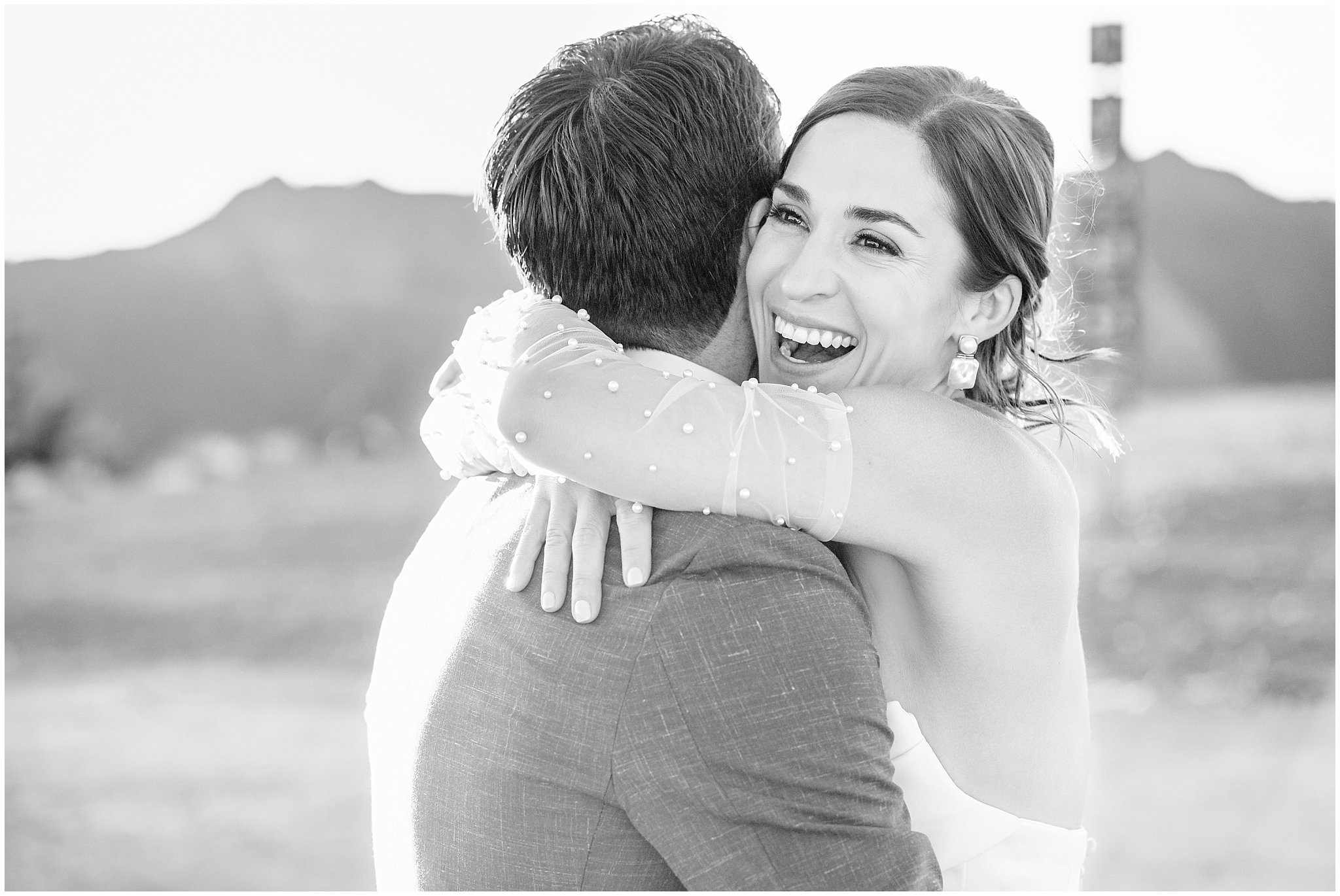 The bride and groom share moments together surrounded by the mountain peaks. Groom wearing a sage green suit and golden tie, bride in a strapless dress with gloves and veil | Snowbird Summit Summer Wedding | Jessie and Dallin Photography